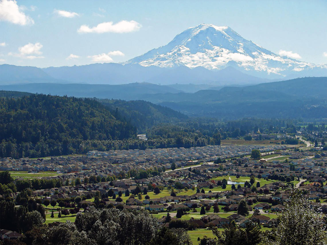 view of mt rainier over homes in the orting valley in pierce county washington